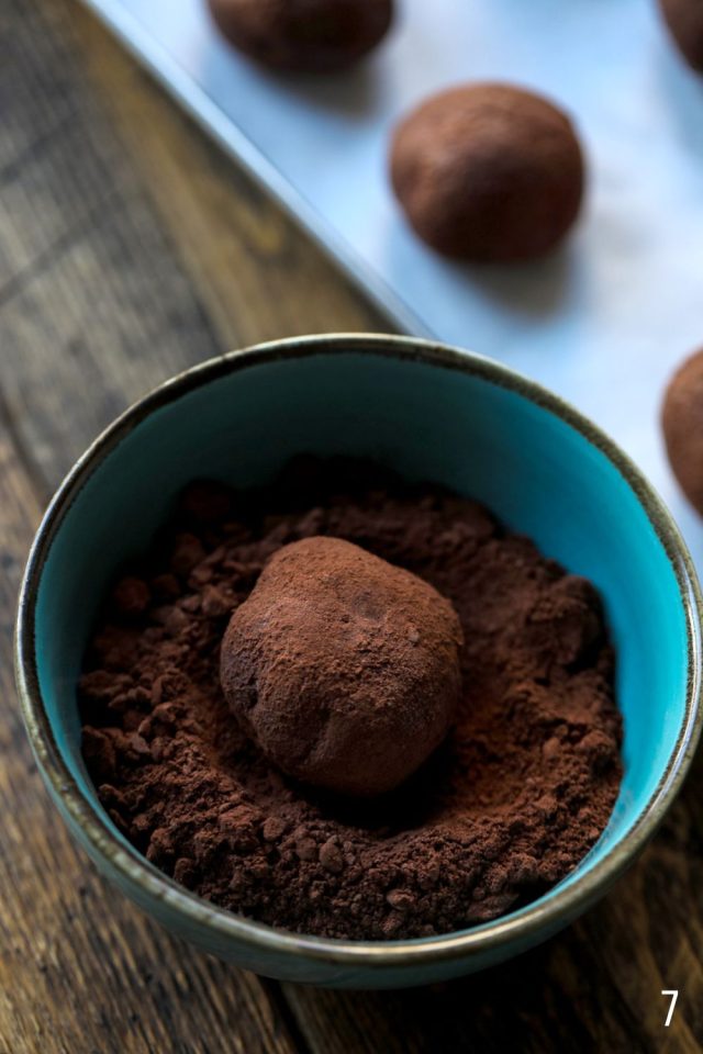 Rolling chocolate truffles in cocoa powder.