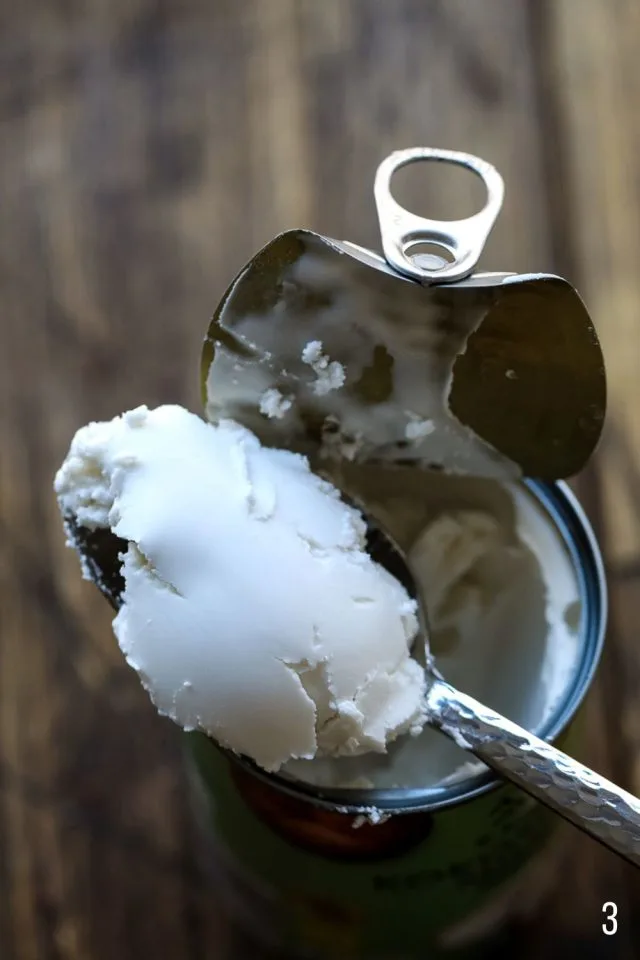 Spoonful coconut cream on a jar of coconut milk