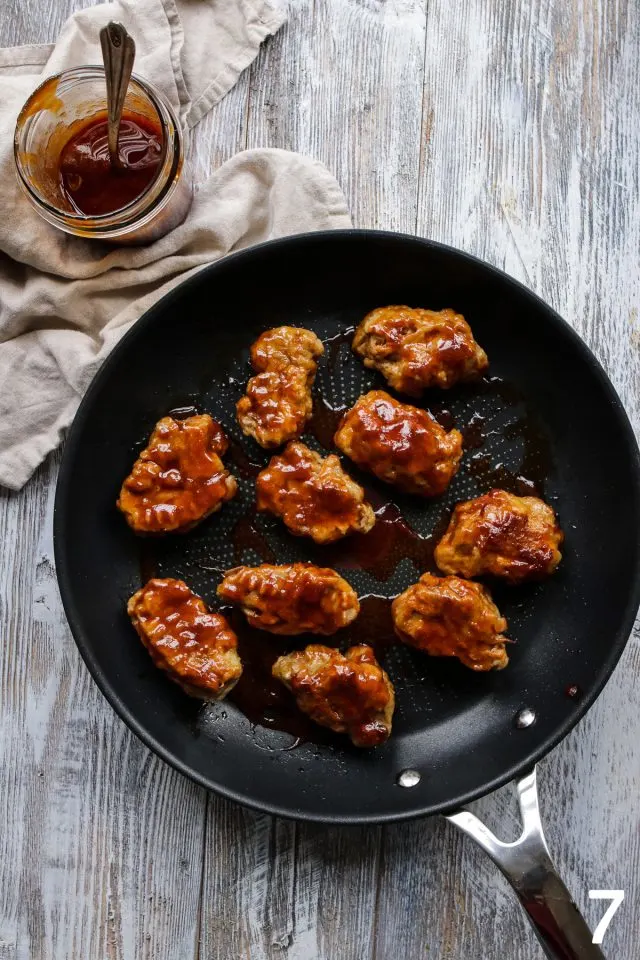 Vegan wings on a frying pan with buffalo sauce.