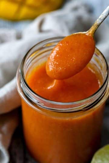 cropped-Holding-a-spoonful-mango-habanero-sauce-over-a-jar.jpg